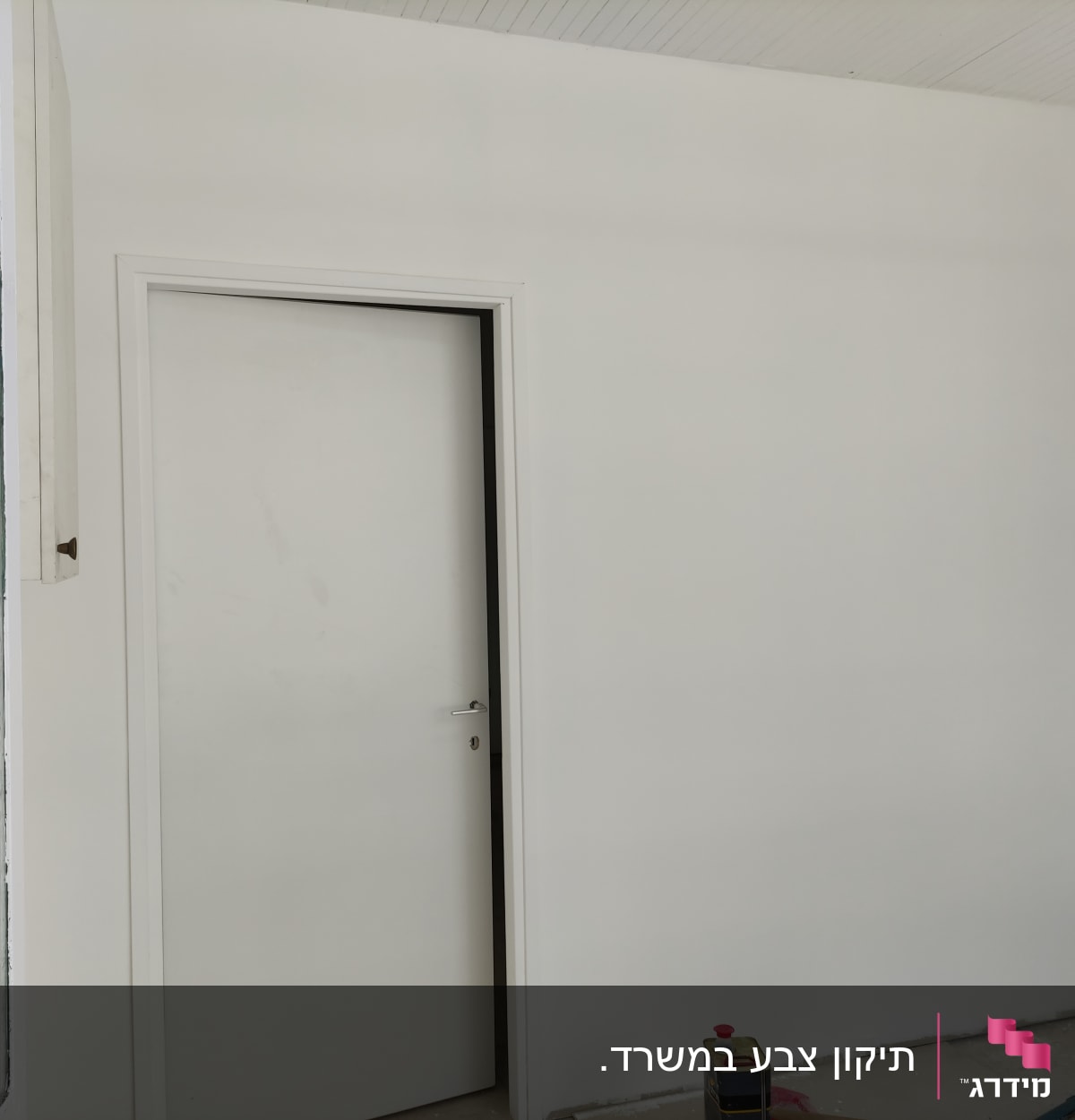 קיר צבוע בלבן עם דלת סגורה, כלי עבודה על הרצפה